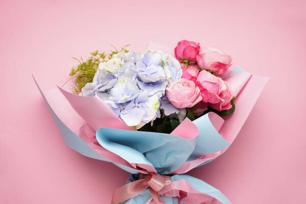 Bouquet of peony roses with hydrangea on a pink background, close up.