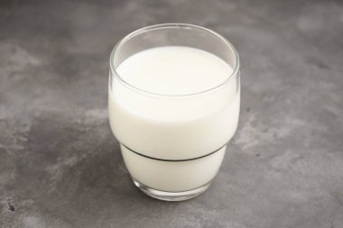 Arka planda gri bir mutfak masasında süt. Yakın plan..