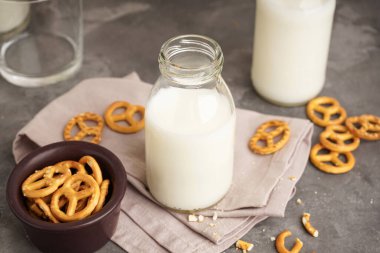 Süt bardakta ve kurabiye şişesi gri masada. Yakın plan..