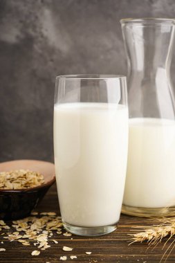 Sütlü yulaf sütü ve tahta bir arka planda yulaf ezmesi. Vejetaryen diyeti kavramı.