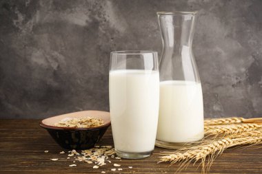 Sütlü yulaf sütü ve tahta bir arka planda yulaf ezmesi. Vejetaryen diyeti kavramı.