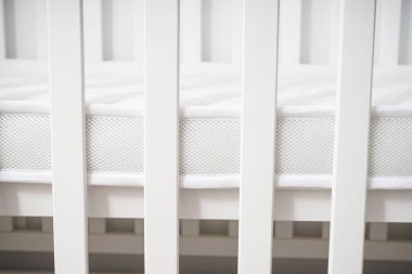 Minimalist, parlak bir bebek odasına yerleştirilmiş, temiz, modern, minimalist bir bebek beşiği. Bebekler için rahat ve güvenli bir uyku ortamı.