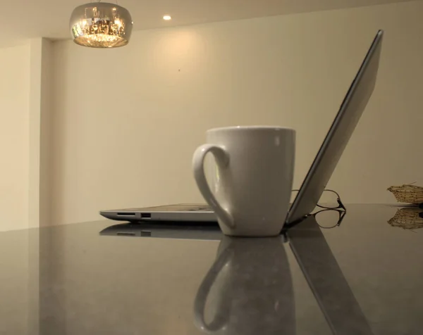Laptop, kahve ve bardaklar masaya.