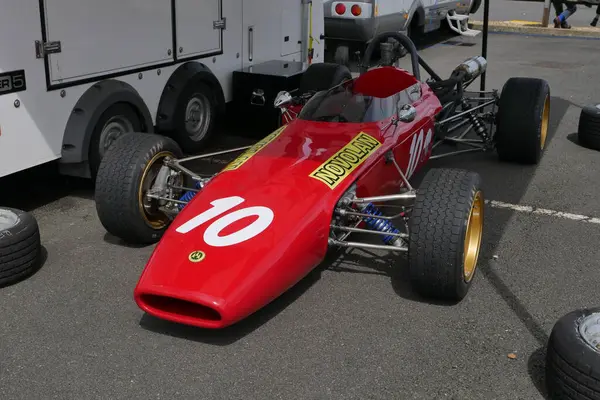 kırmızı klasik araba yolda.