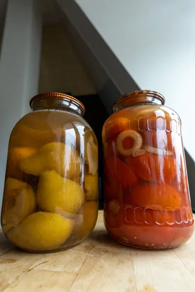 Masada salatalık turşusu ve kırmızı biber olan kavanozlar.