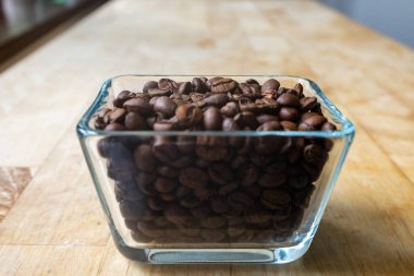 Cam kavanozun içinde kahve ve tahıl dolu bir fincan..