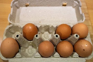 Beyaz arka planda bir kutuda yumurtalar.