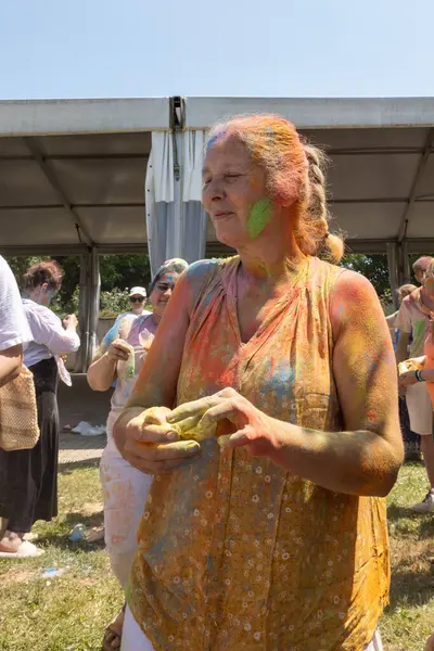 İnsanlar Hint festivalinde eğleniyor ve renkler sergiliyor.