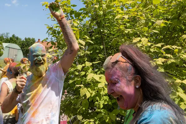 Yüzünde renkli pudra olan bir grup insan..
