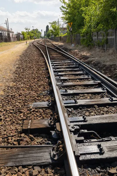 Mavi gökyüzünün arka planında eski paslı tren yolu var.