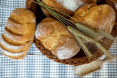 Tahta bir arka planda, sepette ekmek ve rulo.
