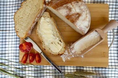 Ahşap bir masada dilimlenmiş ekmekle ev yapımı ekmek.