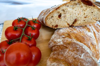 Tahtada ekmek ve baharatlı taze ev yapımı domatesler.