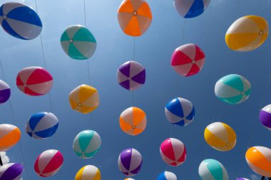 Mavi gökyüzü arka planında renkli balonlar.