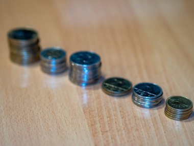 Tahta bir masanın üzerinde bir sürü farklı para yatıyor.