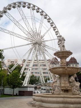 Şehrin arka planında dönme dolap var.