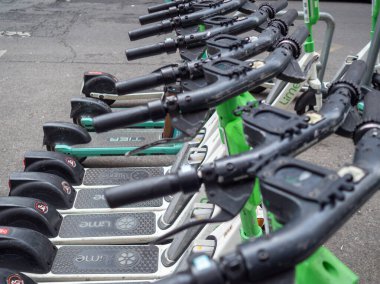 Yeşil arka planda kiralık elektrikli scooter.