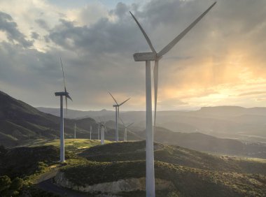 Gün batımının arka planında kırsalda güzel bir rüzgar türbini. Rüzgar türbinleri yel değirmeni güç çiftliği. Carratraca, Malaga, İspanya 'nın eteklerinde..