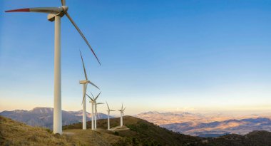 Gün batımının arka planında kırsalda güzel bir rüzgar türbini. Rüzgar türbinleri yel değirmeni güç çiftliği. Carratraca, Malaga, İspanya 'nın eteklerinde..
