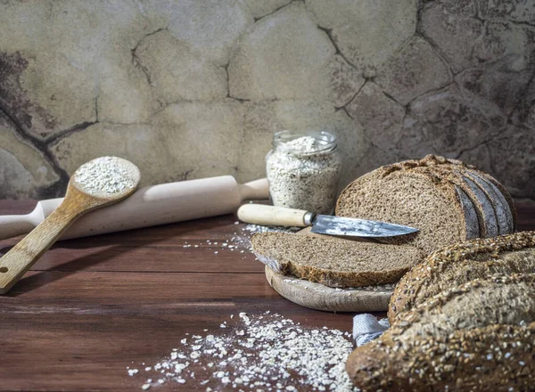 Taze ekmek, tam buğday ekmeği ve doğranmış ekmek. Kırsal ahşap tahtada. Kopyalamak için boşluk. Antika duvar arkaplanı.