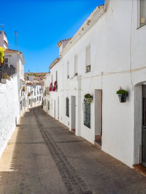 Beyaz evleri, saksıları ve çiçekleri olan Endülüs köyünün dar sokakları. Mijas Malaga. İspanya.