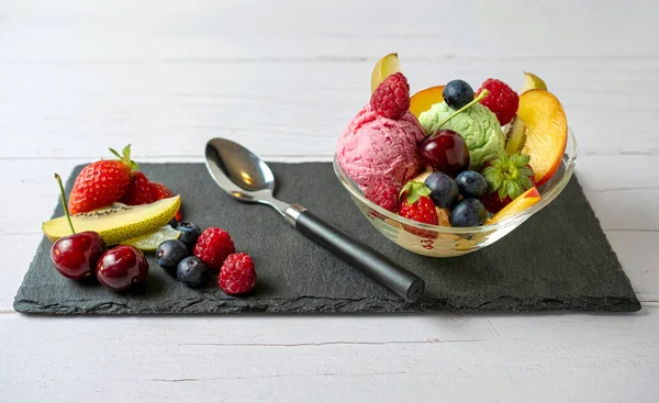 水果沙拉 加香草冰淇淋 开心果 放在盘子里 白色背景隔离 — 图库照片