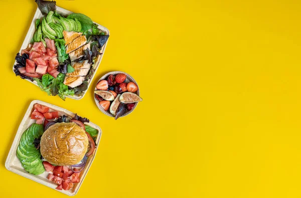 stock image Food containers with healthy take-away food on yellow background top view mock-up.