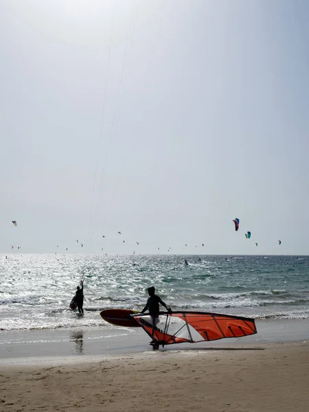 stock image Unrecognizable wearing his wind surf. In the background unrecognizable kite surfing.