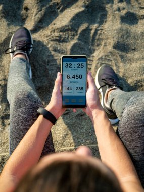 Cep telefonunda çalışan uygulamayı izlerken dinlenen kız.