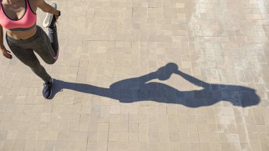 Kadın koşmadan önce geriniyor. Fitness ve yaşam tarzı konsepti.