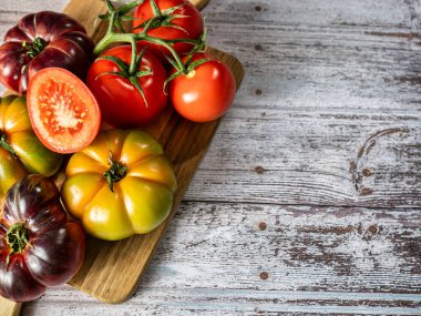 Köy ahşap arka planda tahta bir tahtada taze domatesler. Domates hasadı. Üst görünüm