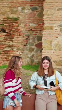 İspanya 'nın Malaga şehrinde iki kız kulaklıkla müzik dinliyor..