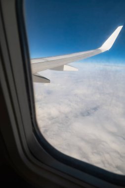 View from an airplane window, airplane wing and white clouds clipart