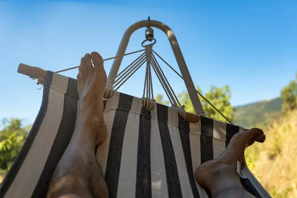 Stock image Horizontal photo of a man's legs in a hammock resting on a hot summer day.