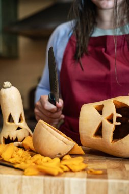 Becerikli kız Cadılar Bayramı süslemeleri yapıyor, aile evde toplanmış kutluyor ve balkabakları üzerinde çalışıyor..