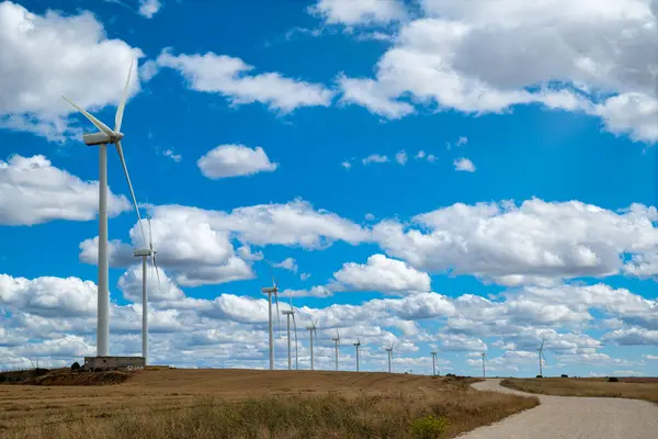 Rüzgar tarlası, rüzgar türbinleri, bir tarlada alternatif enerji santrali, güneşli ve bulutlu bir gün..