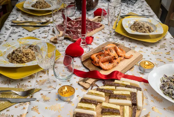 Noel 'i kutlamak için bir masa dolusu yemek, nugat, karides, jambon ve mantarlı pilav. Kurdeleli, kalpli ve yanan mumlu Noel süslemeleri..