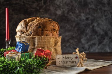 Geleneksel İtalyan Panettone Noel 'i kutlamak için hediyeler ve Noel süsleri, sıcak bir ışık ve sıcak bir atmosferle çevrili..