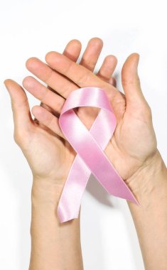 An open hand holding a pink ribbon on a white background, concept of fight against cancer, breast cancer prevention. clipart