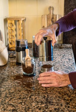 Adam sabahları evinin mutfağında bir moka tenceresini kapatıyor. Gelenek, sıcaklık ve yeni bir günün başlangıcı..
