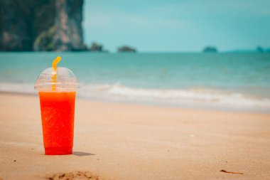 Tayland sahilinde kırmızı papaya içkisi ve dağ arkası.