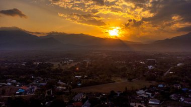 Altın gün batımı Mae Rim 'i aydınlatıyor ve kuzey Tayland' daki Chiang Mai yakınlarındaki dağları aydınlatıyor..