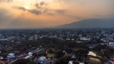 Chiang Mai, Tayland 'ın havadan görünüşü, kentsel yayılma, yemyeşil yemyeşil ve Doi Suthep dağları batan güneşe karşı kirli tozlu hava ile kaplıdır.