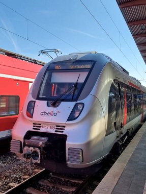 Abellio Bombardıman Yeteneği 2, Sınıf 442, güneşli bir günde, Almanya 'da Saalfeld istasyonunda, istasyonun çatısının altında kırmızı bir trenin yanında park halinde.