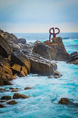 El Peine del Viento es un conjunto de tres esculturas de acero de ms de 9 toneladas cada una, que se sita all donde la ciudad y comienza el mar, donde las olas abrazan los abruptos acantilados del Monte Igueldo, Baha de La Concha