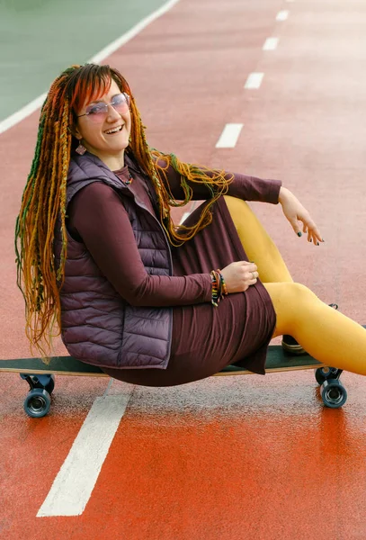 Zabawny Wolny Hipster Kobieta Dredami Siedzi Longboard Drodze Jazdy Mieście — Zdjęcie stockowe