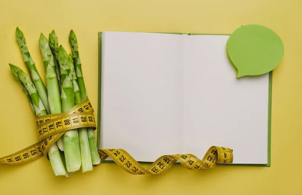 アスパラガスと分離黄色のテープを測定します 減量の概念のための食事とバランスの取れた栄養食品 レシピ用ノートブック内のスペースをコピー — ストック写真