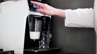 Ev yapımı kahve makinesi sıcak latte ya da kapuçino yapıyor. Bardakta süt buharı var. Yakın plan. Kahve makinesini aç. Sabah sıcak içkisi. Yakın çekim.