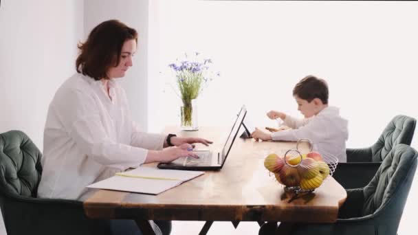 Kobieta Średnim Wieku Pracuje Domu Laptopie Podczas Gdy Dziecko Jedzenie — Wideo stockowe