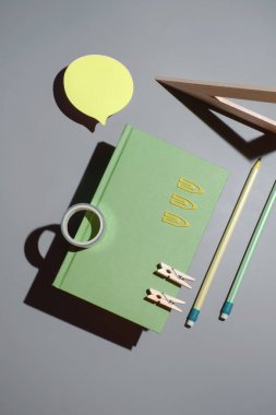 Not defteri, sarı etiket ve mavi arka planda ofis malzemeleri. Ofis arkaplanını kopyala.